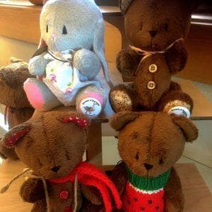 Handmade stuffed animals including bears and a bunny, crafted from fiber materials in a folk art style.