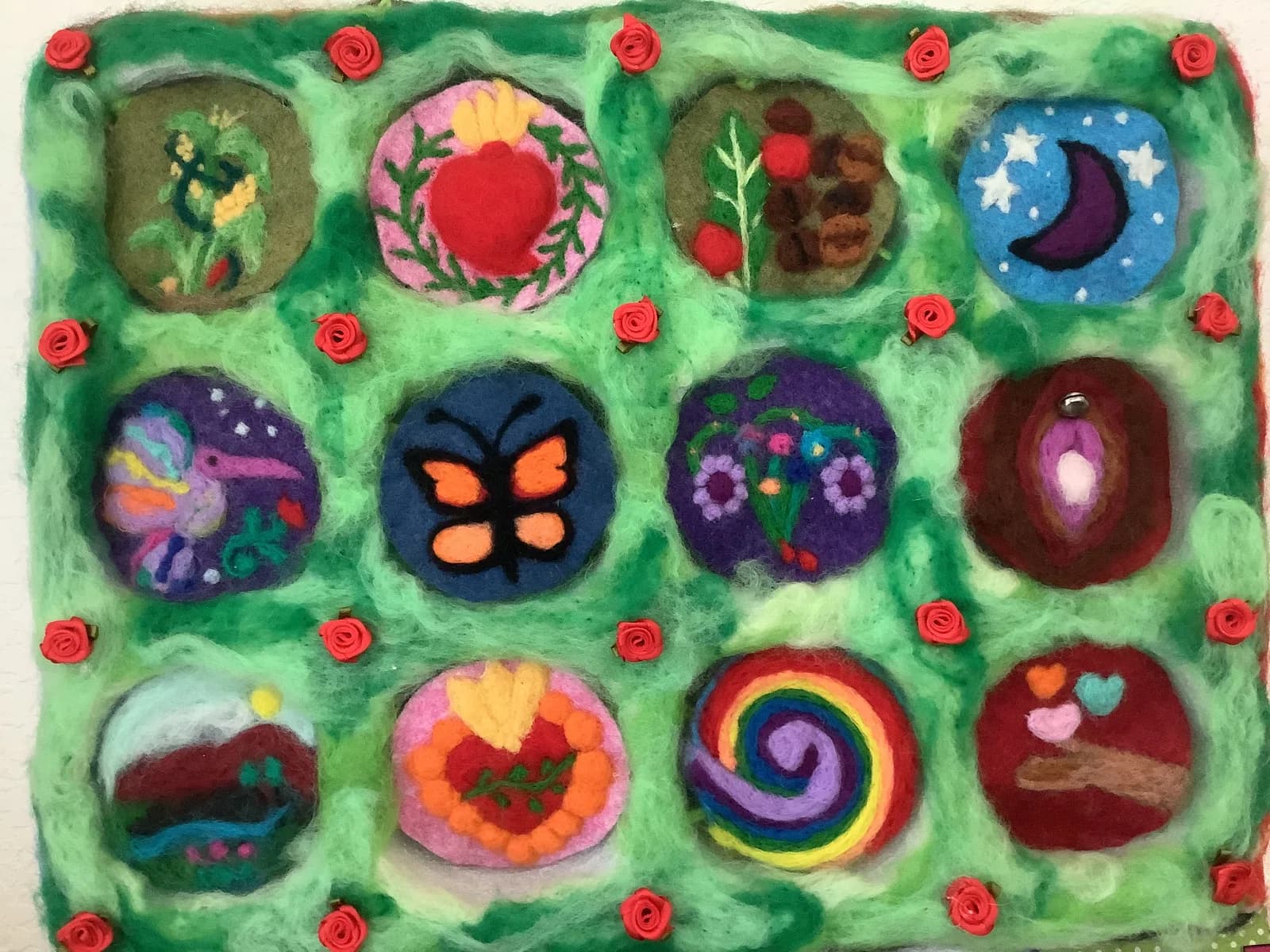 A folk art textile piece features twelve felted roundels with varied motifs on a green background, accented with red roses.