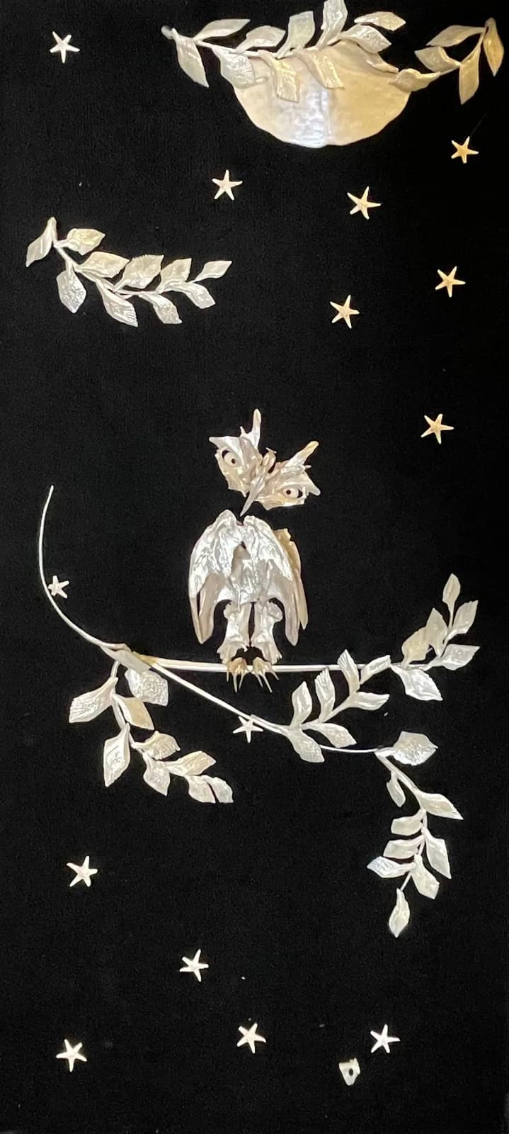 A mixed media assemblage depicts an owl perched on a branch under a moonlit sky with stars.