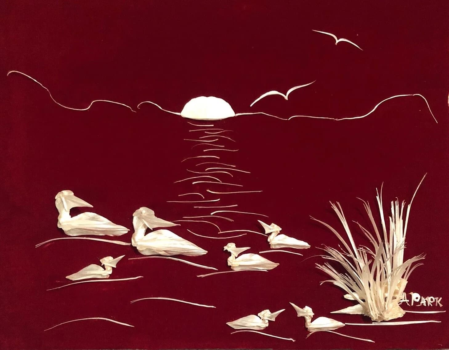 A mixed media artwork depicts pelicans on the water at sunset with reeds.
