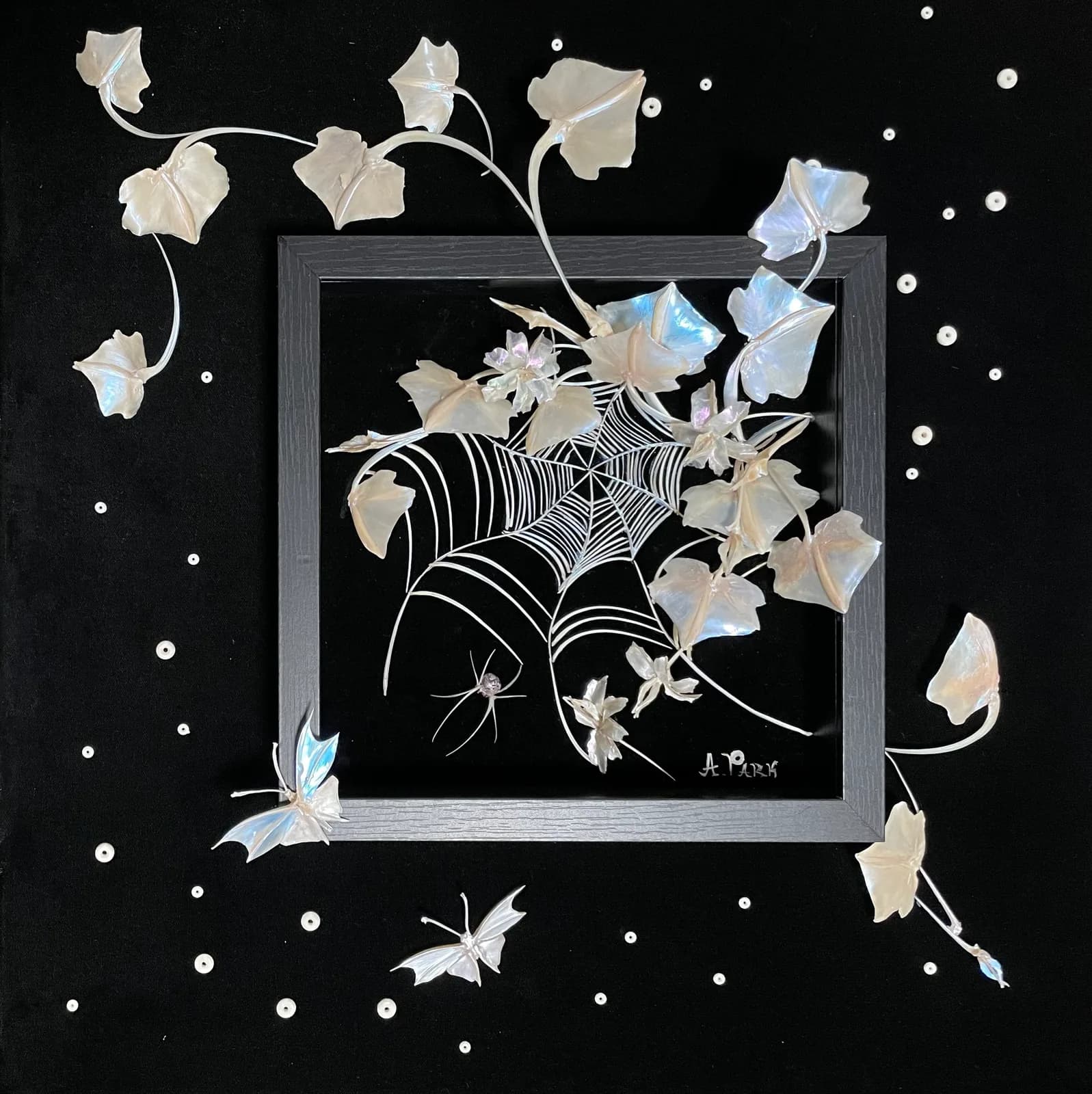 A mixed media artwork features a spiderweb with ivy and butterflies against a dark background.