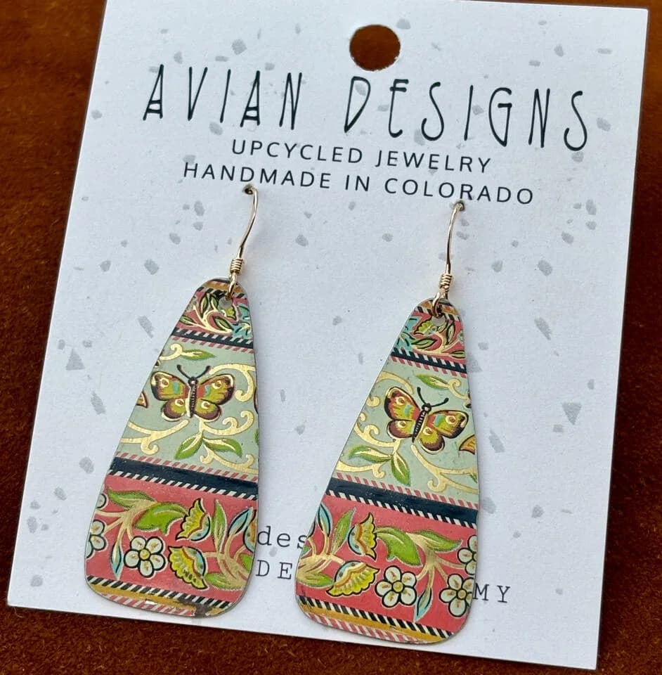 Upcycled metal earrings featuring a butterfly and floral motif in a palette of Redwood, Barley Corn, and Swamp Green.