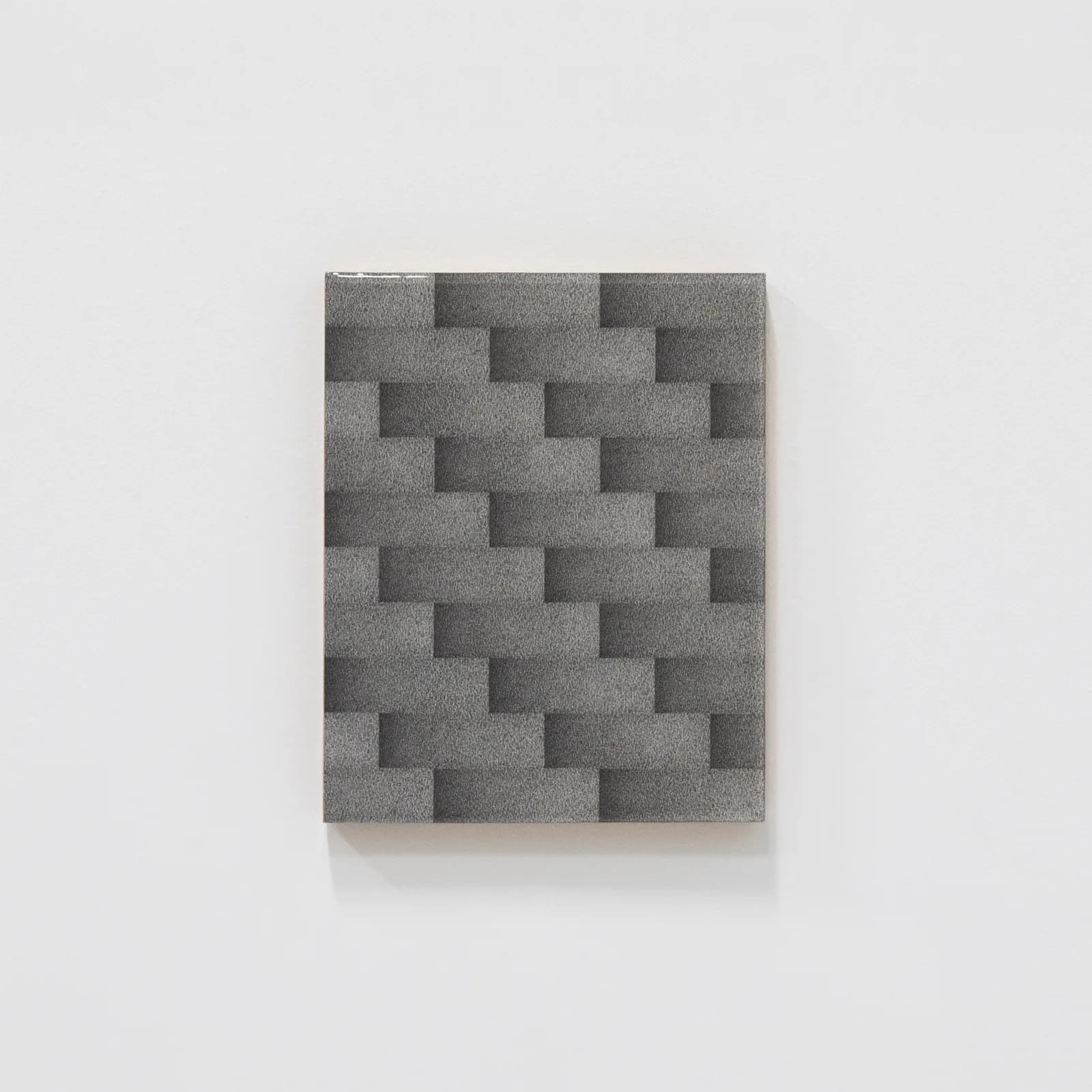 A geometric painting in shades of gray depicts a repeating pattern of staggered rectangles, rendered with a textured, granular effect.