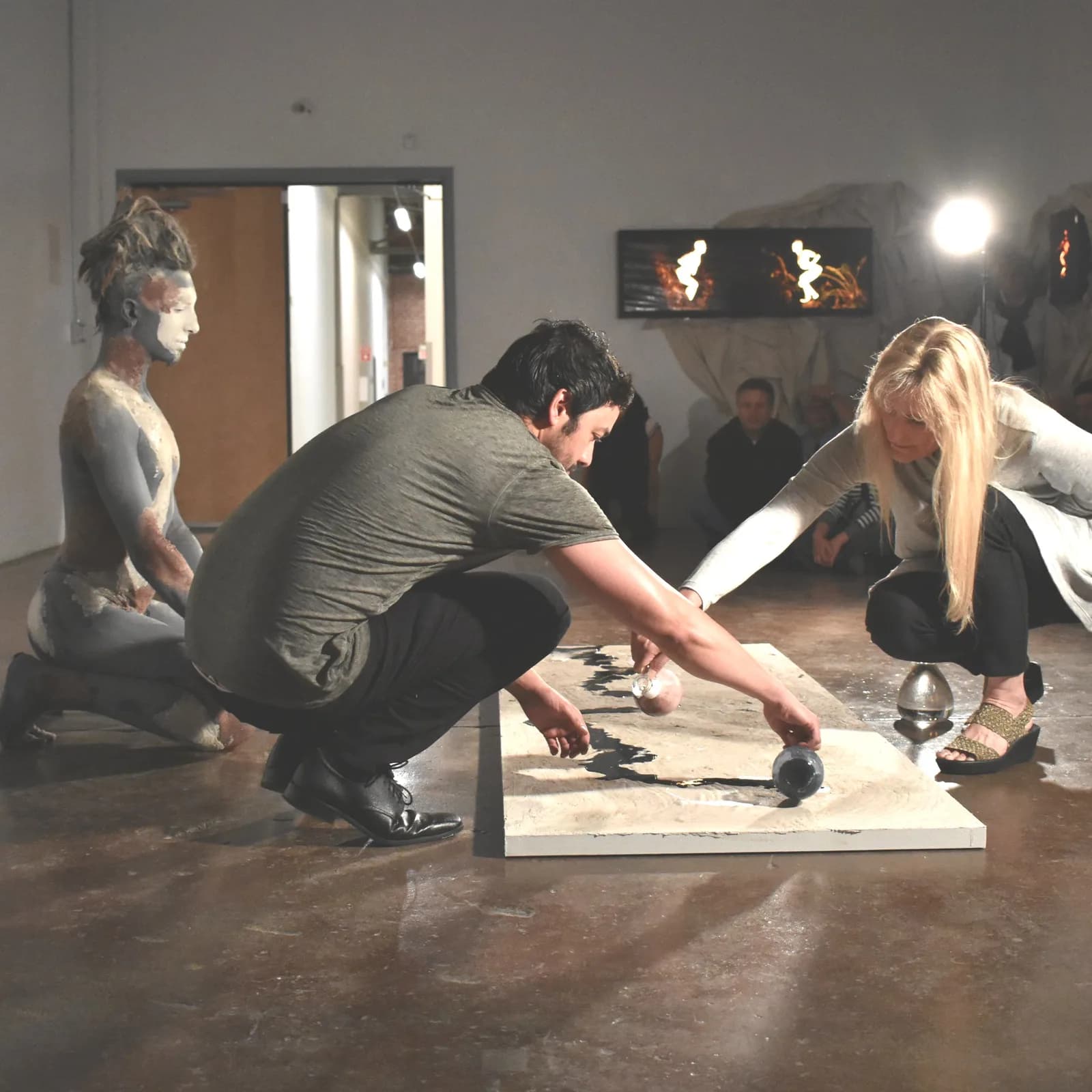 Artists engage with a mixed media installation during a performance art piece.