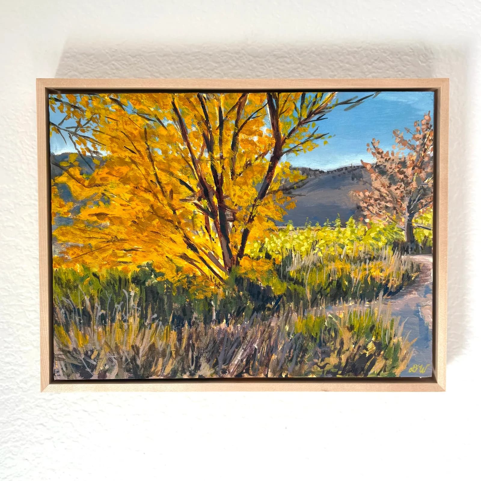 An impressionistic oil painting depicts a vibrant fall landscape with golden trees and a winding path.