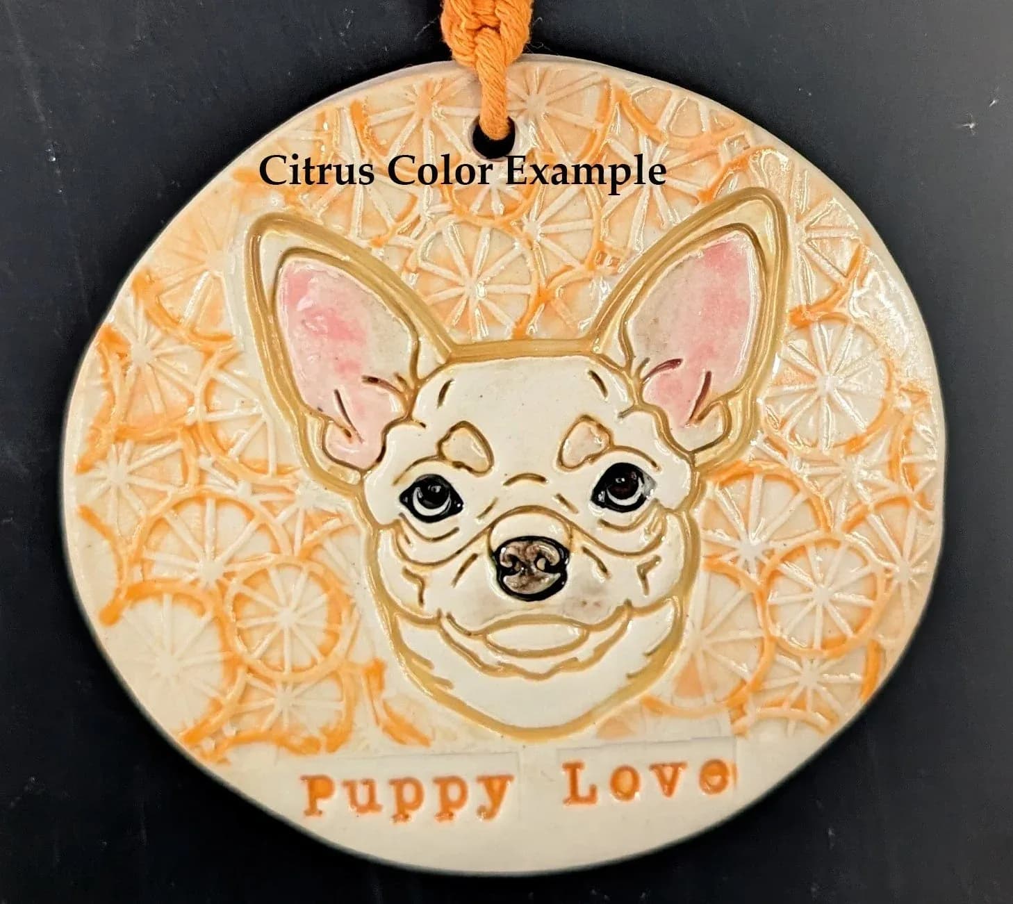 A ceramic ornament featuring a chihuahua's face against a citrus-patterned background, with the text "Puppy Love."
