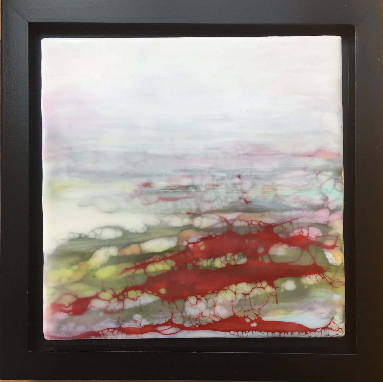 An abstract painting in oil and acrylic features vibrant red and green hues against a pale background.