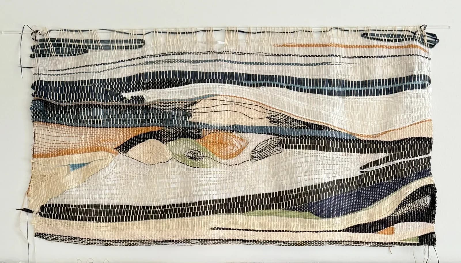 An abstract woven textile art piece in muted tones of Muddy Waters, Sisal, and Bison Hide.