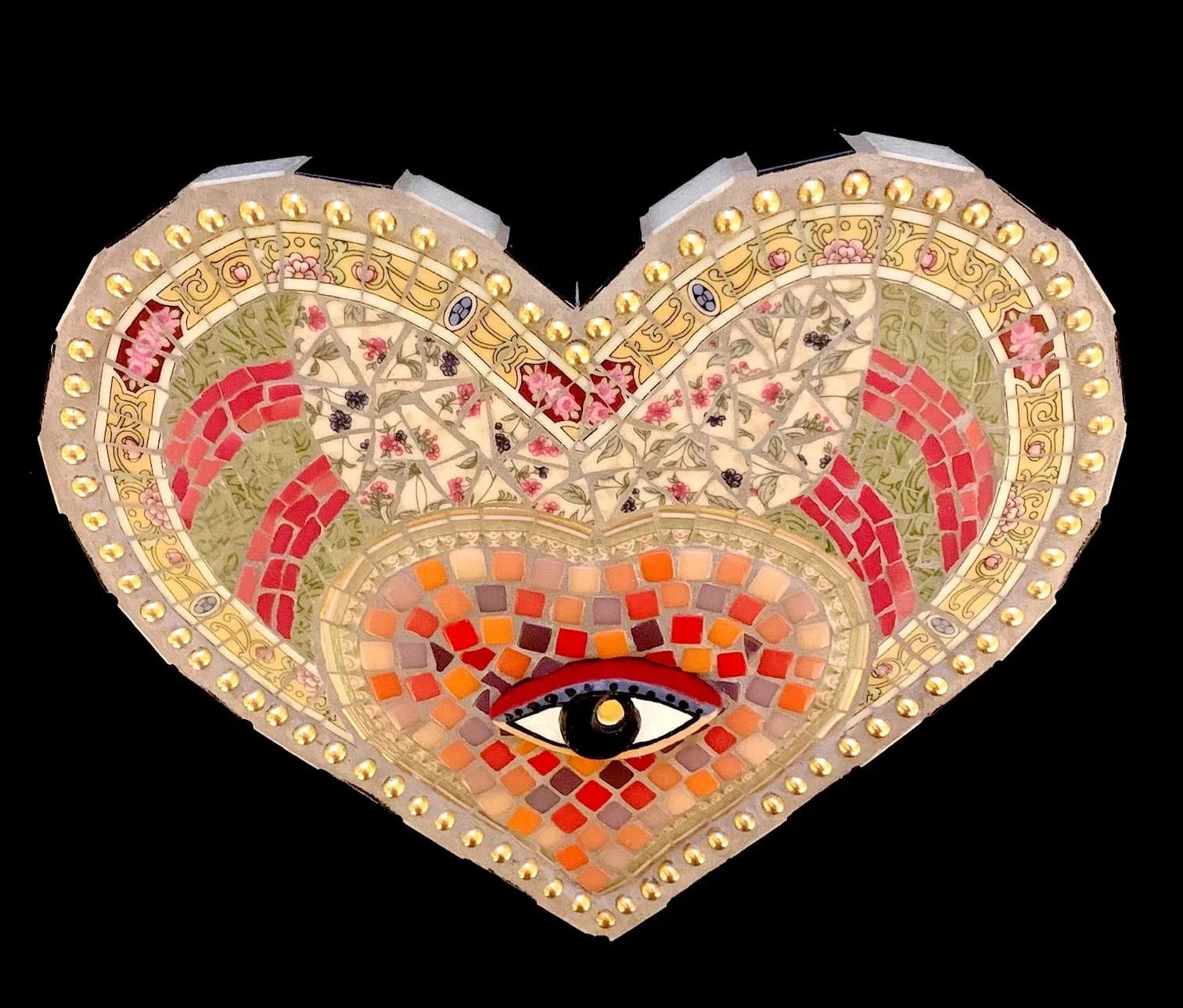 A heart-shaped mosaic artwork featuring an eye, crafted from glass tiles in Roman, Persian Red, Tan, and Wheat hues.