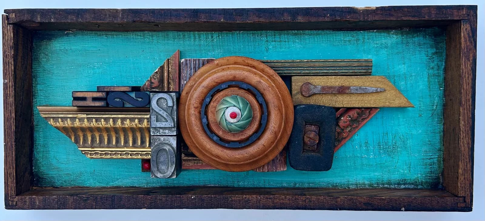 An abstract mixed media assemblage features found objects and typography against a vibrant blue background.