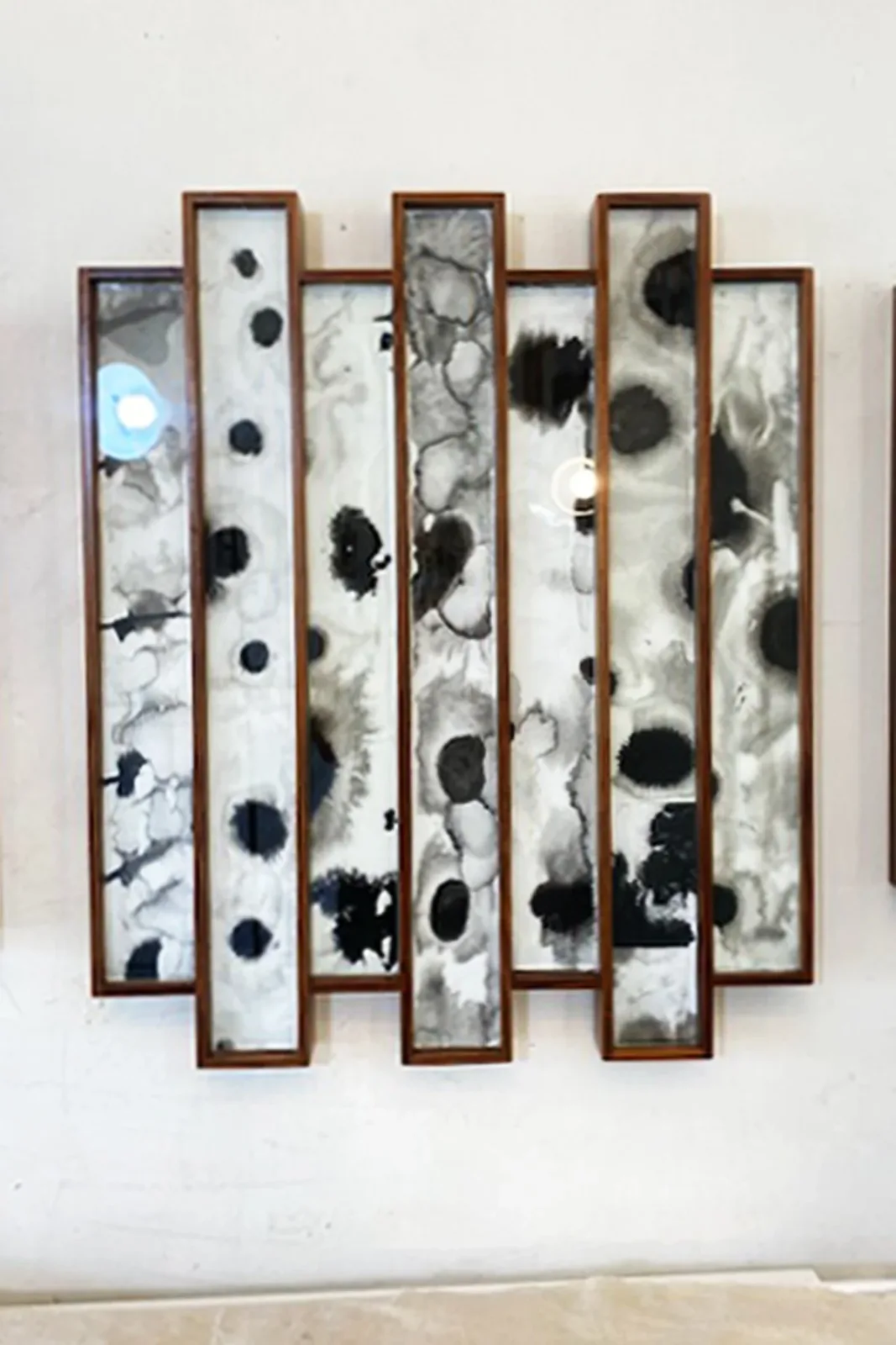 Abstract ink wash paintings in monochrome tones are presented in a vertical, multi-panel format.