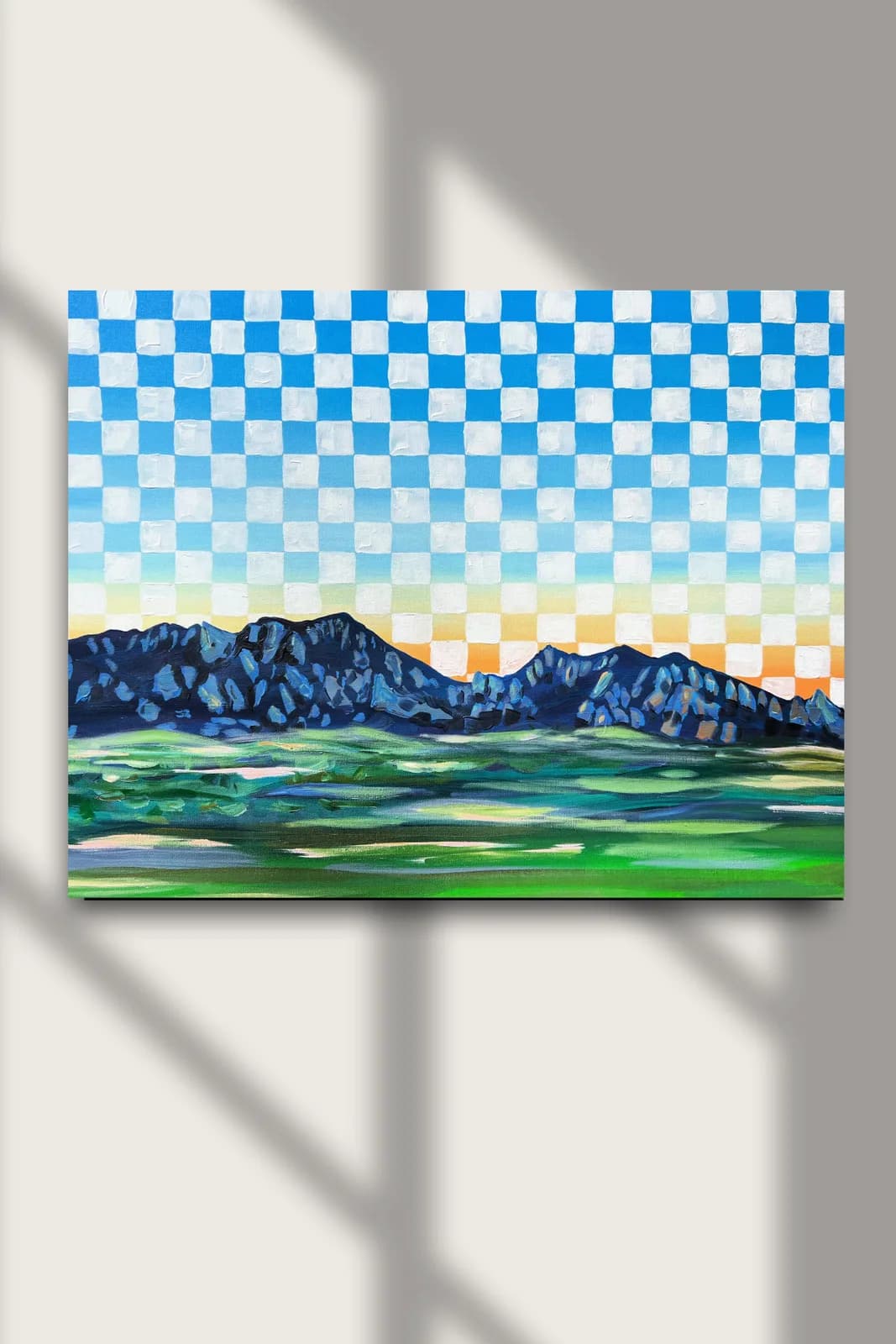 A landscape painting of the Flatirons at sunset with a checkerboard sky in shades of blue and orange.