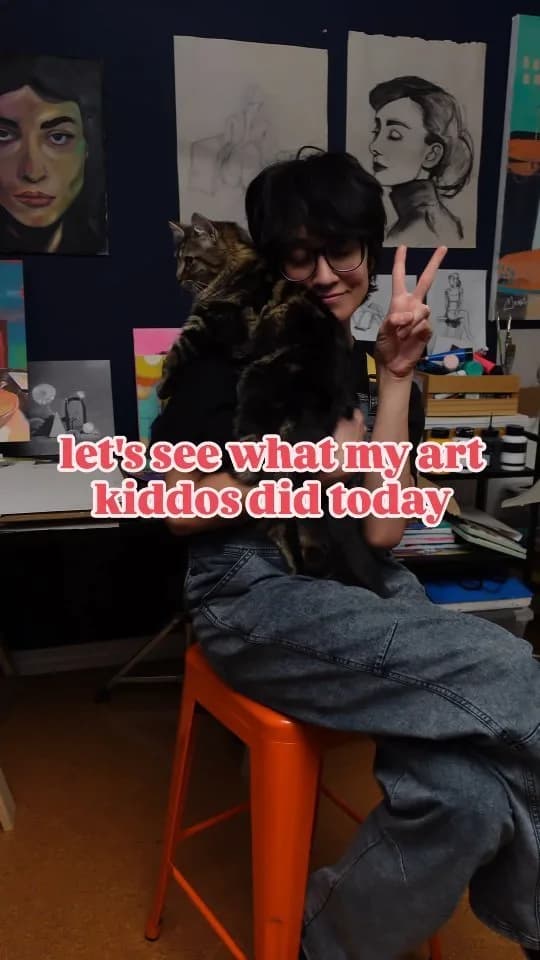 A portrait painting of a woman is displayed in a furnished studio setting with an artist holding a cat.