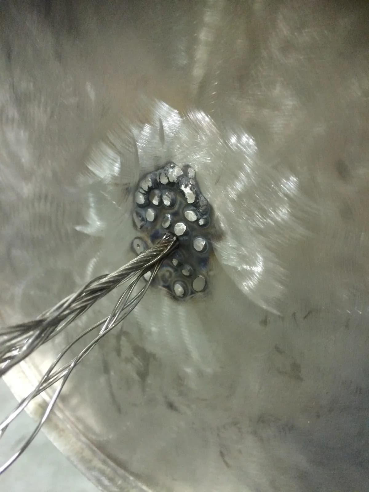 A close-up of metalwork with cables attached, showing texture and detail.