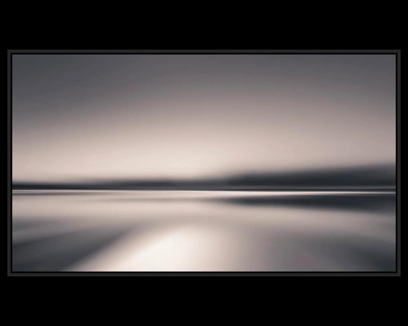 An abstract landscape photograph captures a serene horizon with muted tones of gray and silver.
