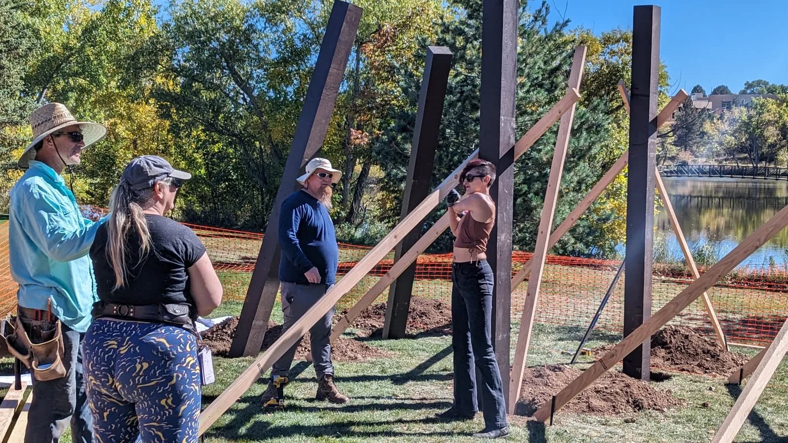Installation of a large wooden sculpture in progress with artists on site.